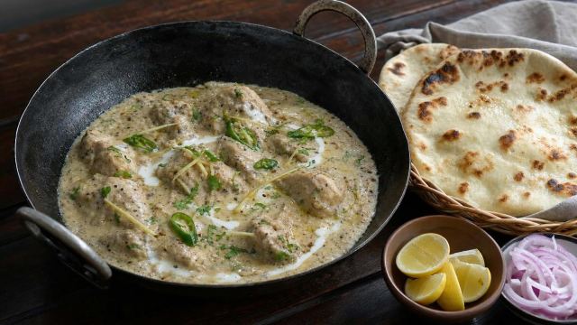 White chicken karahi in a creamy yogurt sauce with ginger and green chillies in a black karahi